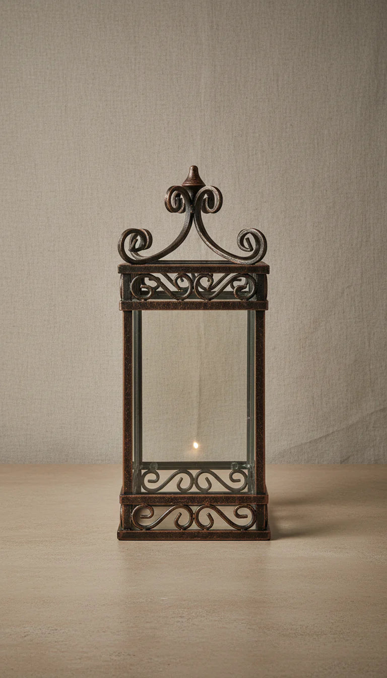 Handcrafted forged iron scrollwork lantern with clear glass panels and decorative finial top