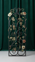 Taureanlace Botanical Iron Garden Panel with sculpted roses, grape clusters, and vine scrollwork against a deep green velvet backdrop